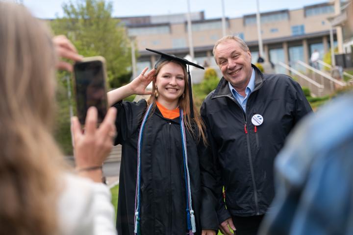 An Olin College graduate poses for a photo after Commencement with a parent.