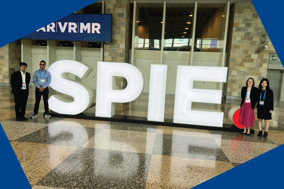 Fun image of student team with the SPIE conference sign
