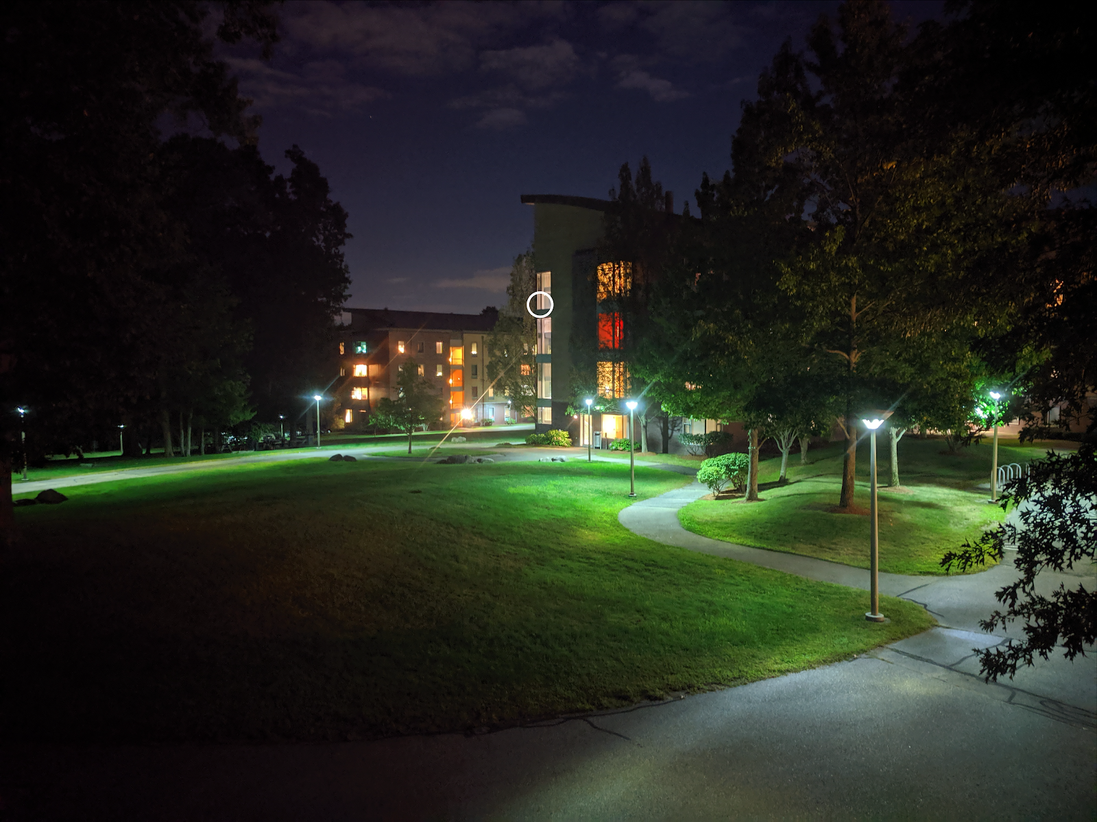 The outside of Olin's West Hall residence hall at night, with a stairwell on the fourth floor circled for emphasis.