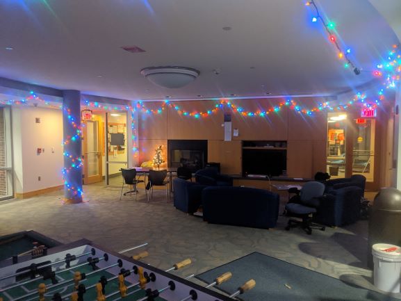 The West Hall 1 lounge with seating, string lights, and a foosball table.