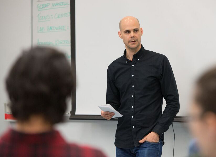 A photo of Aaron Hoover standing in front of the classroom