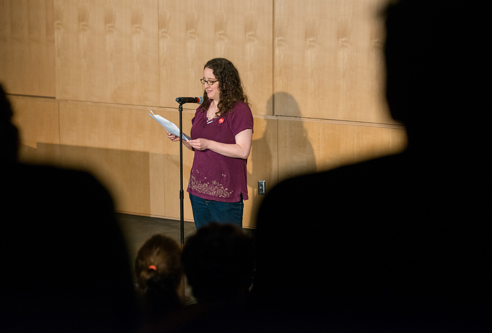 A woman standing in front of a microphone on a stage