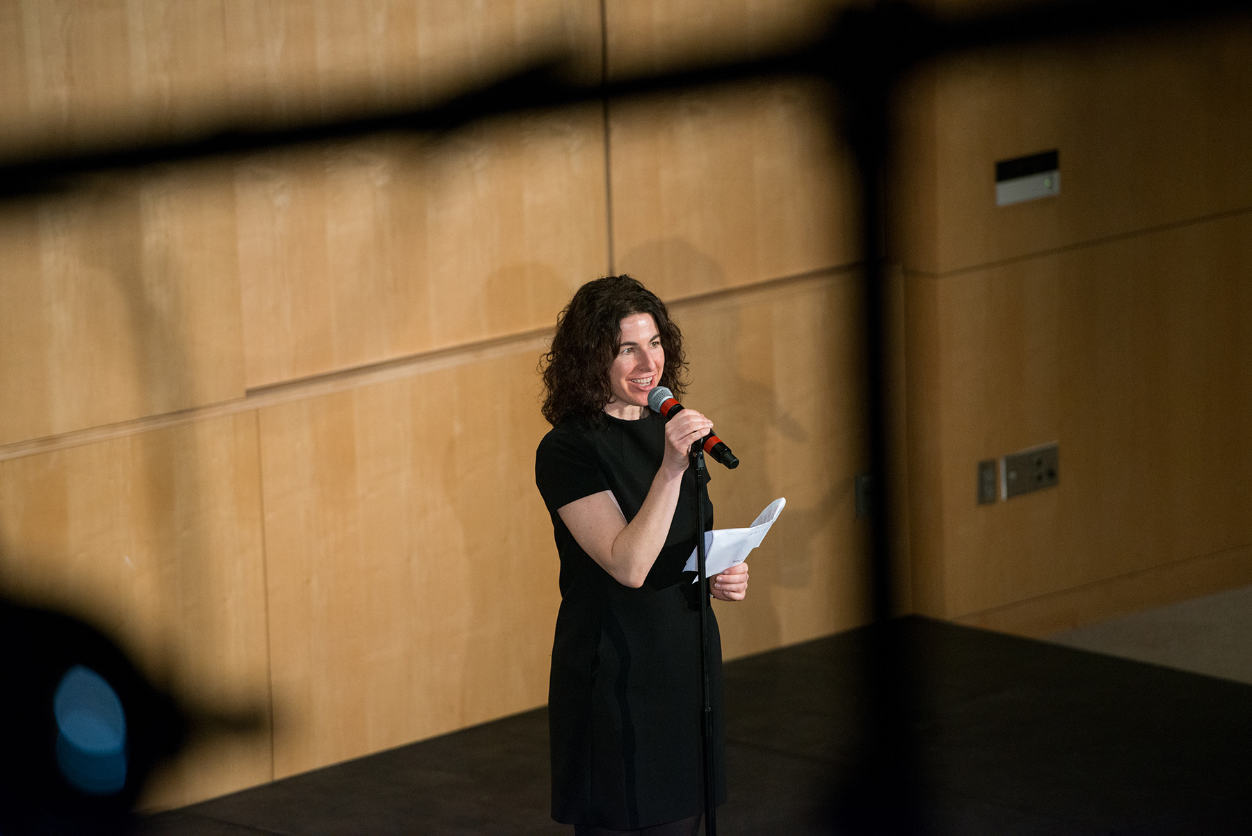 A woman standing on a stage holding a microphone