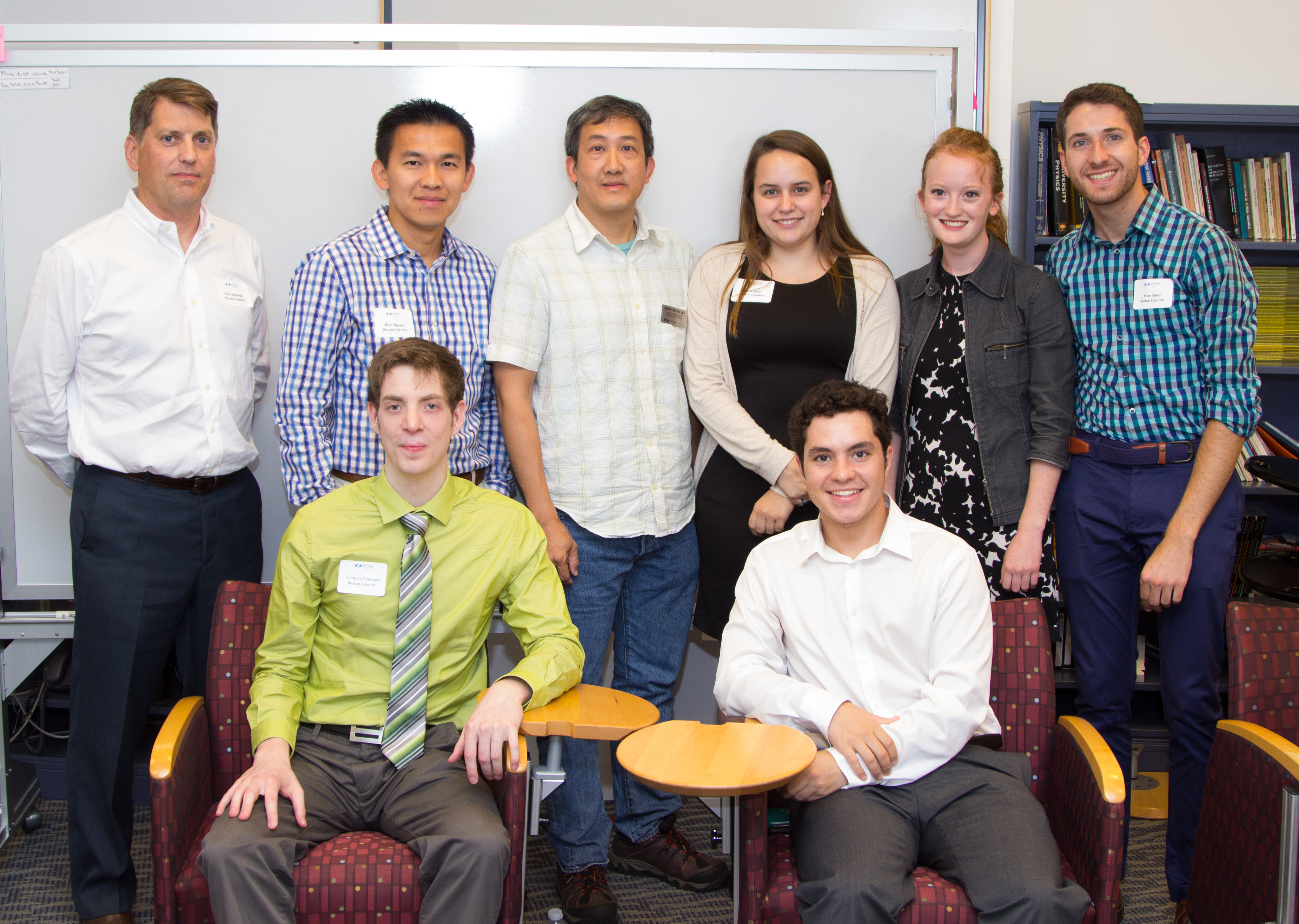 team members sitting and standing smiling