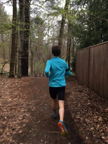 The author running on a trail in the forest.