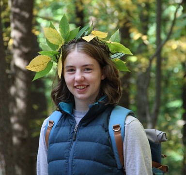 The author standing in the woods with a crown of leaves.