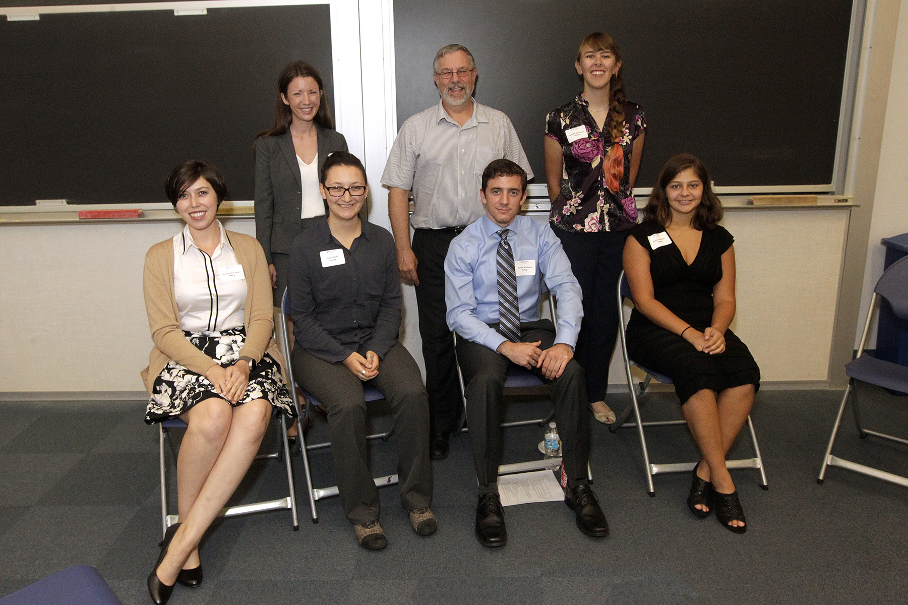 team members sitting and standing smiling