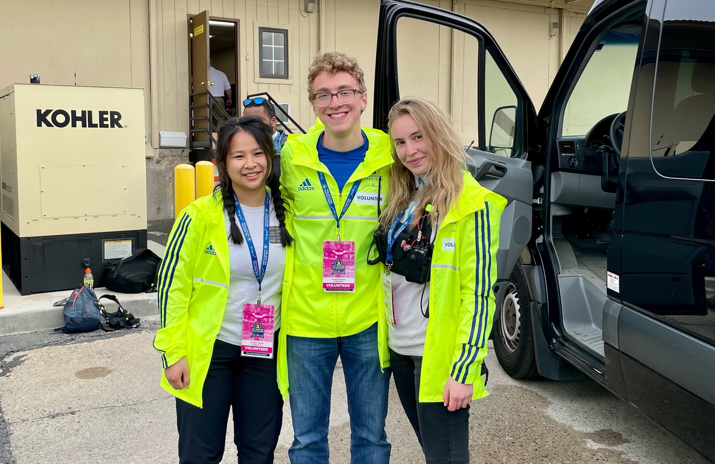 Three OCARC members pose for a photo at a staging area for the 2022 Boston Marathon.