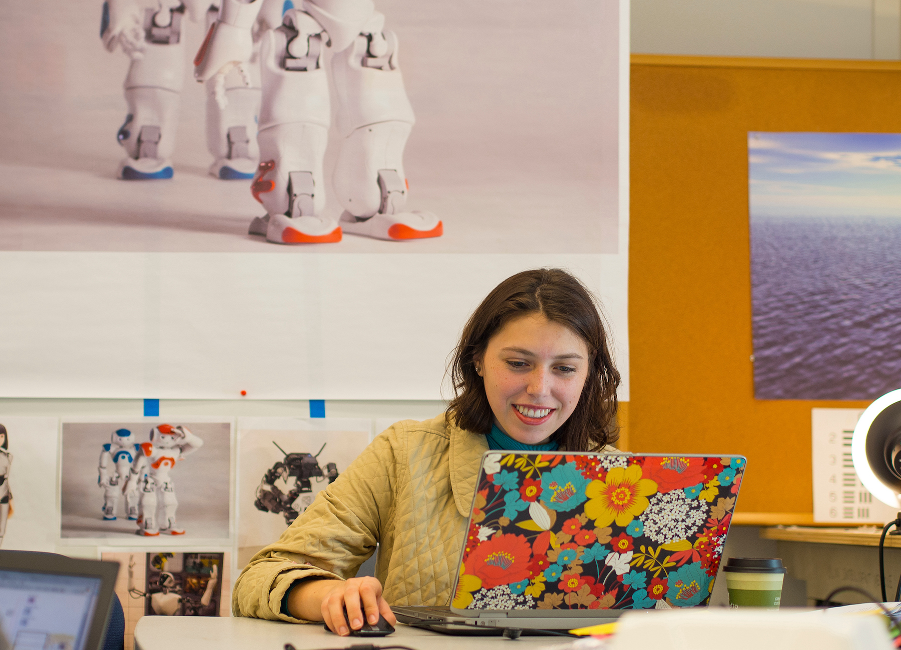 An Olin student works on their flower-covered laptop on Olin's campus.