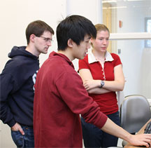 three students looking at a computer