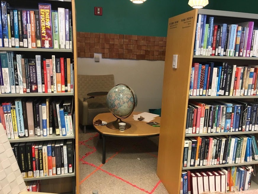 An opening between two bookshelves revealing a cozy seating area.