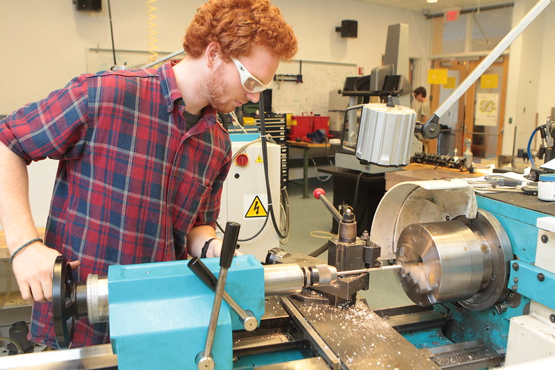A student working with a machine in the Olin Shop.