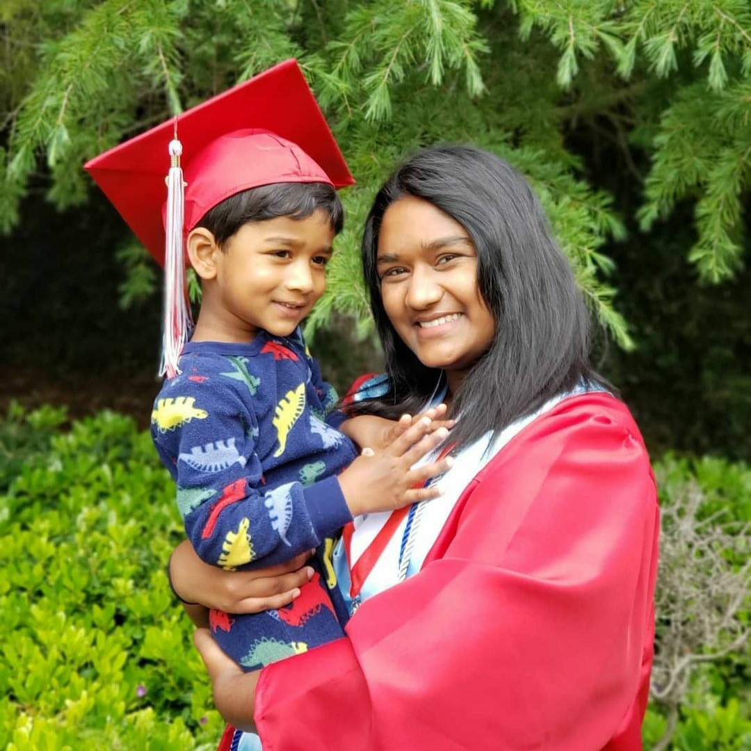 The author at a graduation, holding her little brother.