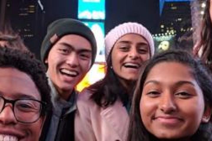 Selfie of a group of friends in Times Square in New York City at night
