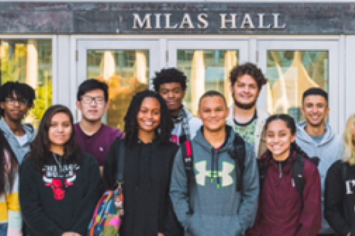 A group of students standing outside in front of a building labeled "Milas Hall."