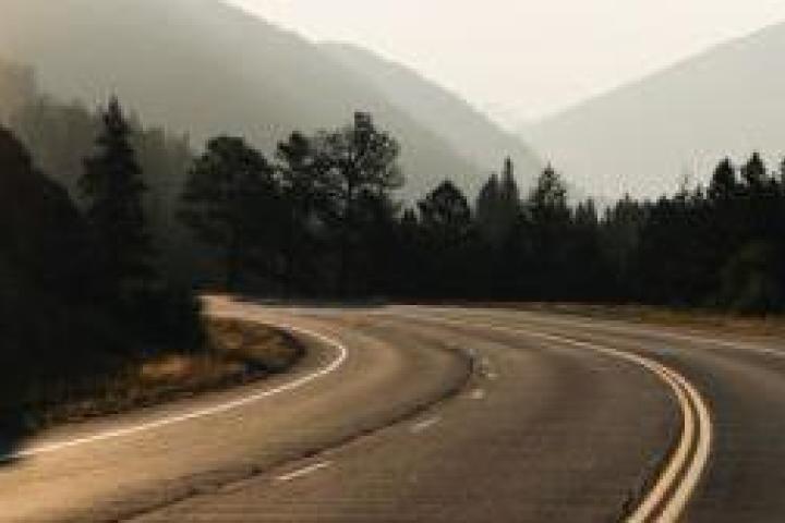 A highway going off into woods and mountains.