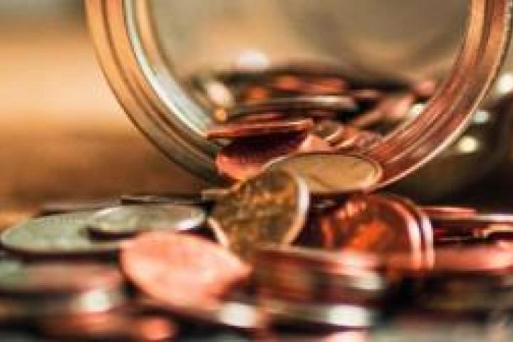 Coins spilling out of a jar onto a table