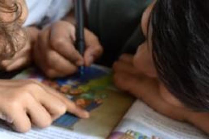 Closeup of two children sharing a book