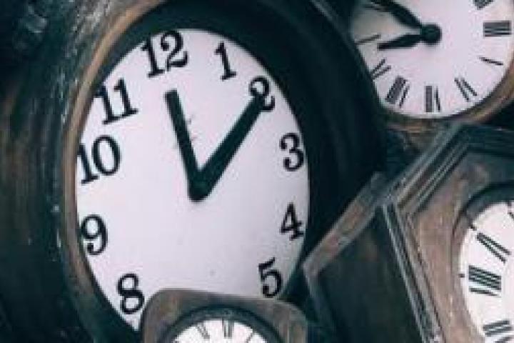 Closeup of several clocks displaying different times.