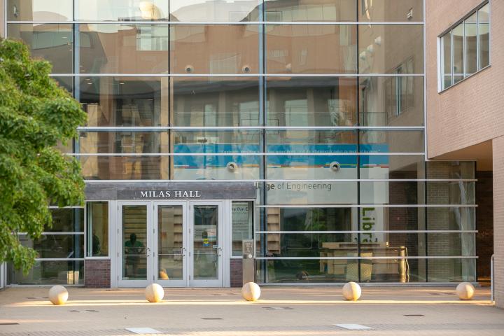 Exterior view of a building with glass windows covering the length and width of the entryway.