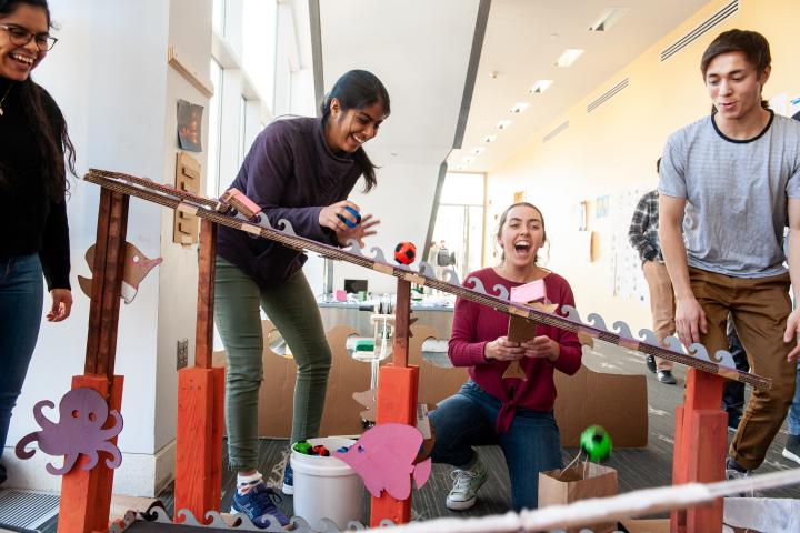 a photo of four people laughing while working on engineering project