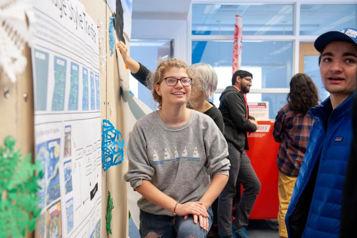 a photo of a women standing in front of a poster and smiling