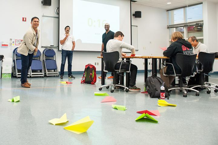 A photo of a classroom where a person is throwing paper airplanes