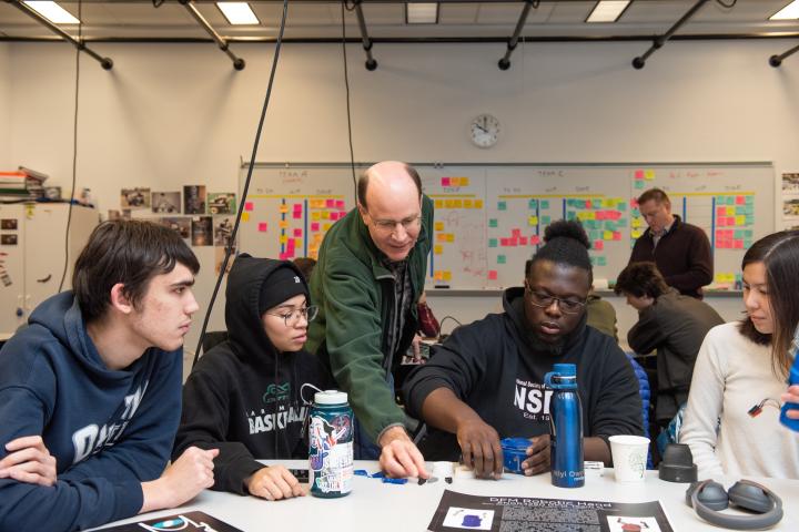 A photo of a group of people in a classroom working on a project