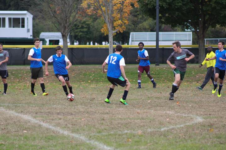 The Olin College soccer team mid game a photo of a group of people playing soccer