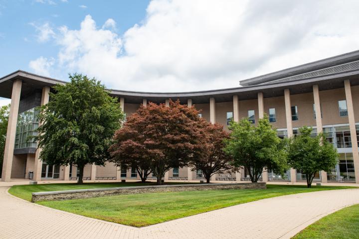 A photo of a large curved building with multiple columns