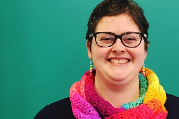 A photo of women wearing a rainbow scarf