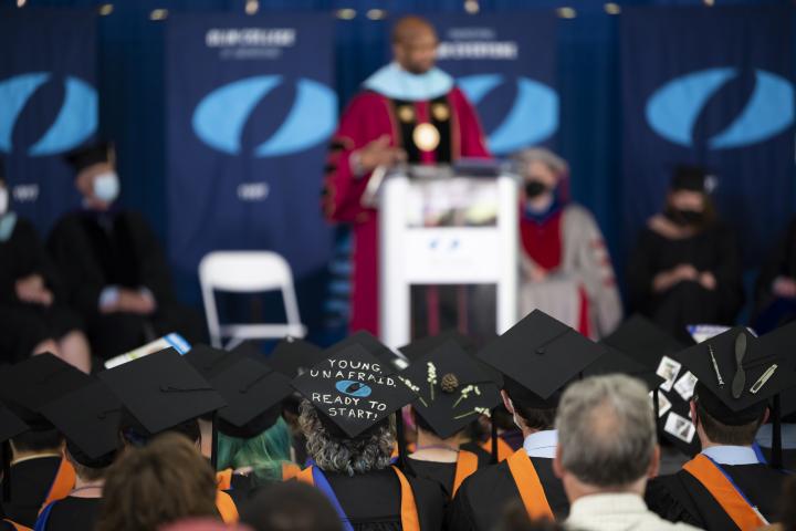 A variety of graduation caps are shown in the crowd as the Class of 2022 listen to the Commencement Speaker.