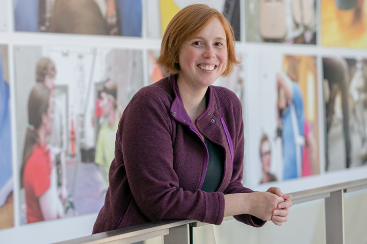 A photo of a woman leaning over a banister and smiling