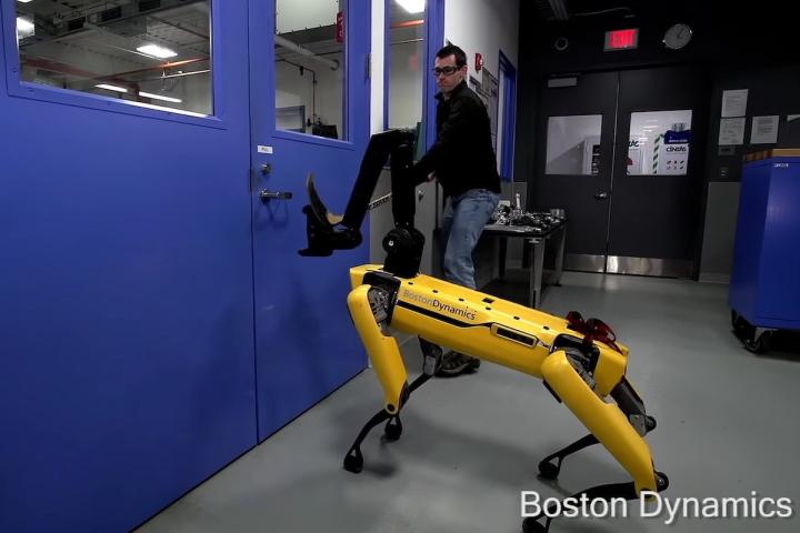 Andy Barry '10 uses a door handle to test the robustness of Boston Dynamics' quadruped robot, Spot.