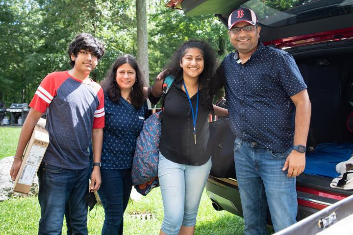 A photo of four people standing arm in arm