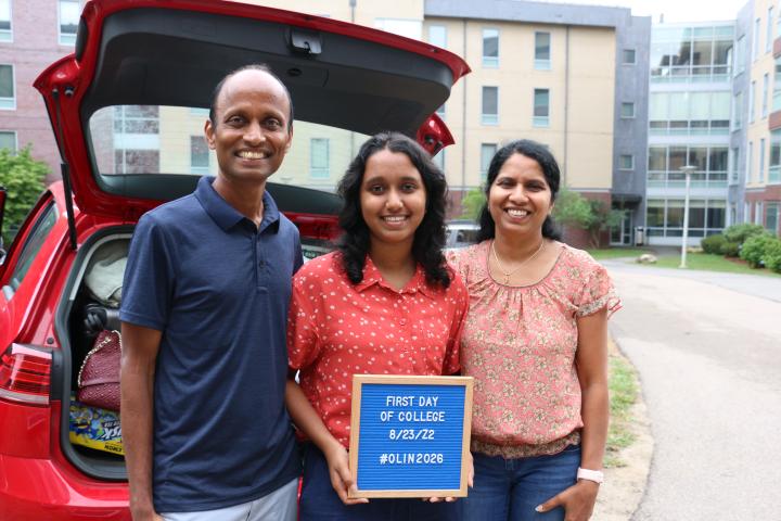 A first year Olin student poses by the trunk of their car with their parents on move-in day at Olin.