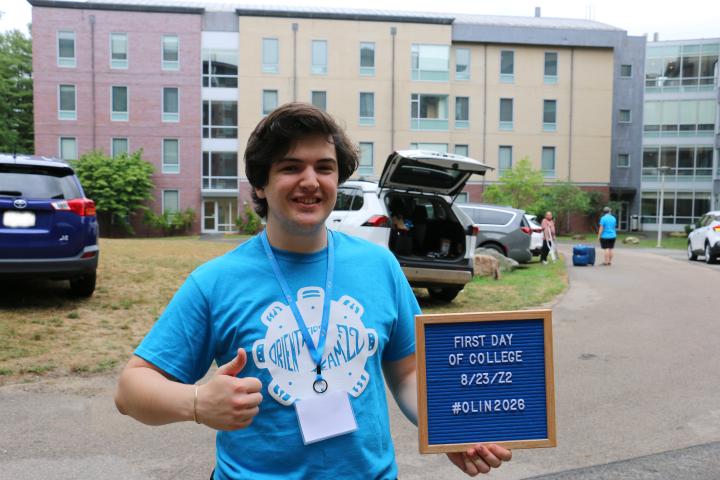Student poses with thumbs-up and letterboard sign at Move-In Day.