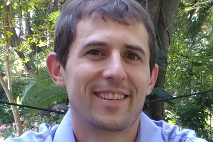 A photo of a man sitting in front of a tree