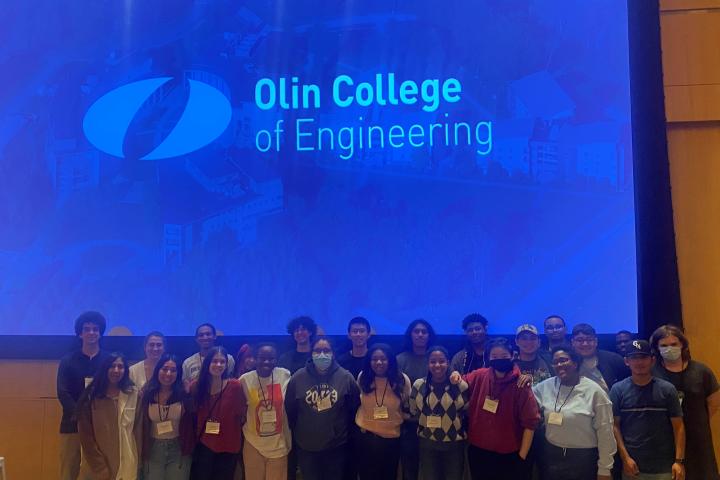 a group of students in front of the Olin College logo