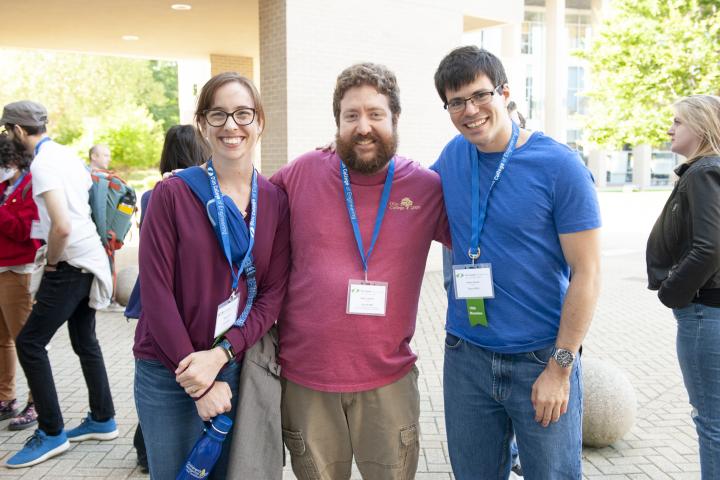 Female alum with glasses and red shirt, male alum with beard and red olin college 2009 shirt, male alum with glasses and blue shirt