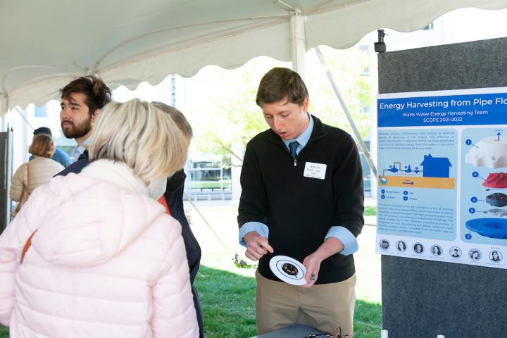 Student holding prototype for visitor