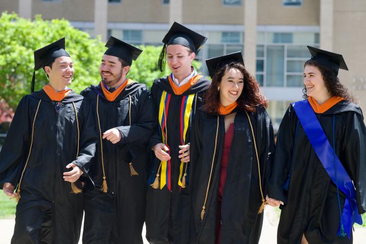 5 Class of 2023 Graduates walking on campus