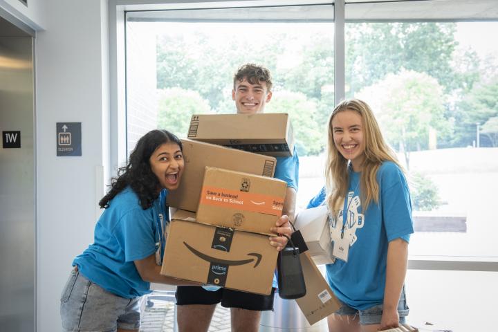 Move-In Day 2022 three r2s holding a stack of boxes awaiting the elevator