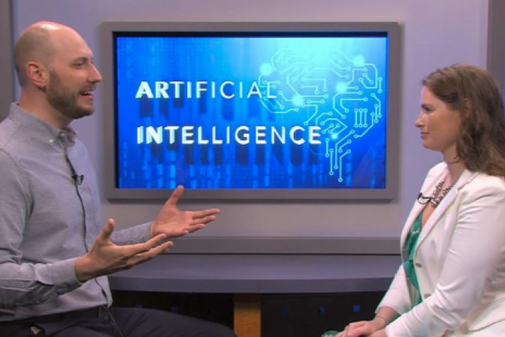 Associate Professor Erhardt Graeff is pictured speaking with the host of the Needham Channel.