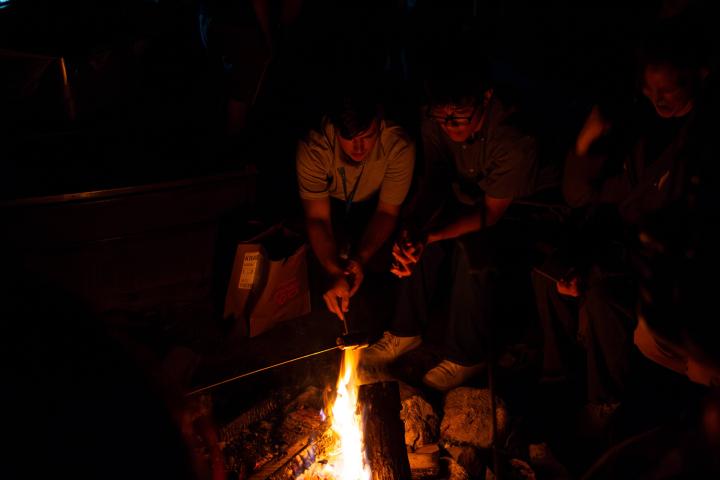 Students are shown roasting marshmallows at the campus fire pit.