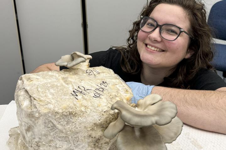 Student Maddy Robertson with class grown mushrooms.