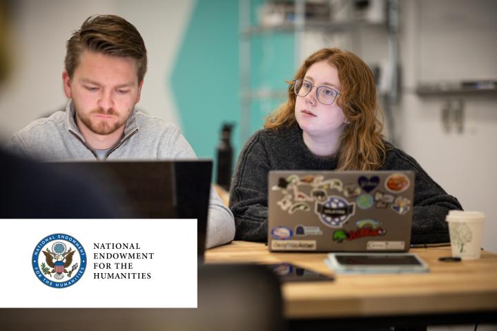 NEH Grant Thumbnail - student looking down at computer next to student looking up at board