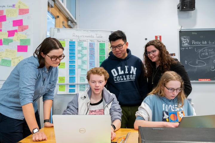 collaboration students collected around laptops