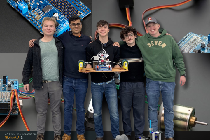 Five college students pose with a real Turing machine; a device they created in their engineering class.
