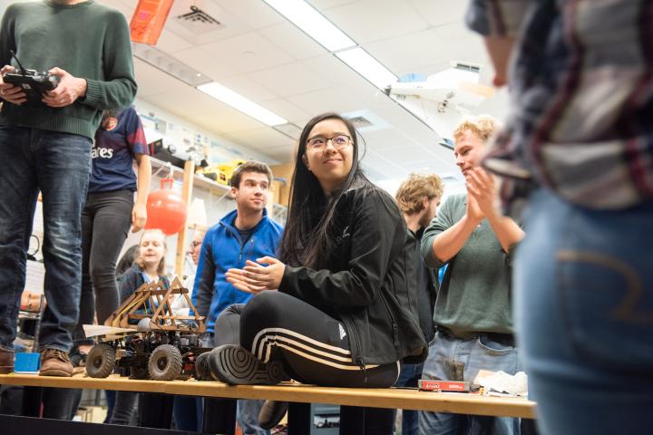 An Olin student sits on a table in the RoboLab at Olin College.